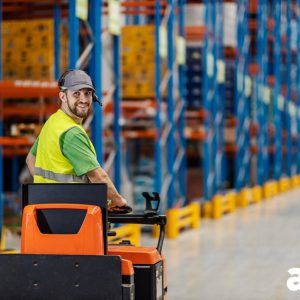 conductor de apilador eléctrico dentro de un almacén logístico