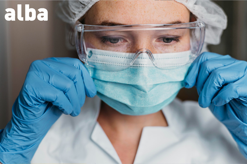 trabajadora poniendose una mascarilla como parte de los epi que tiene que utilizar en su puesto de trabajo